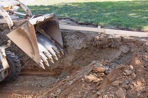 kleiner Bulldozer, der im Hof für die Poolinstallation gräbt foto