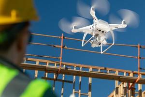 Pilotin fliegt Drohnen-Quadrocopter, die Baustellen inspizieren foto