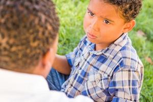 glücklicher afroamerikanischer vater und gemischtrassiger sohn spielen im park foto