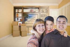 Mischlingsfamilie im Zimmer mit Zeichnung der Unterhaltungseinheit foto