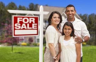 hispanische Familie vor ihrem neuen Zuhause und Schild foto