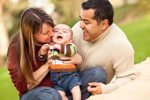 glückliche Eltern gemischter Rassen, die mit ihrem Sohn spielen foto
