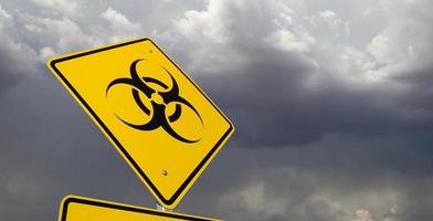 Bio-Hazard gelbes Schild gegen ominösen stürmischen bewölkten Himmel foto