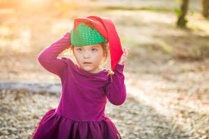 süße gemischte Rasse junges Mädchen, das Spaß hat, Weihnachtsmütze im Freien zu tragen foto