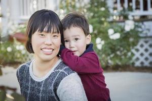 chinesische mutter, die spaß mit ihrem babysohn der gemischten rasse hat foto