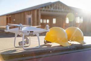 Drohnen-Quadrocopter neben Schutzhelmhelmen auf der Baustelle foto