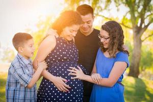 hispanisches schwangeres Familienporträt im Freien foto