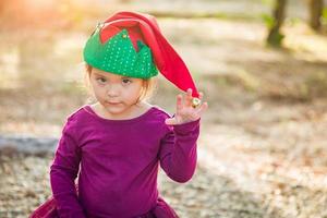 süße gemischte Rasse junges Mädchen, das Spaß hat, Weihnachtsmütze im Freien zu tragen foto