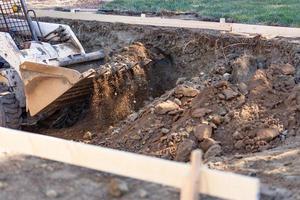 kleiner Bulldozer, der im Hof für die Poolinstallation gräbt foto