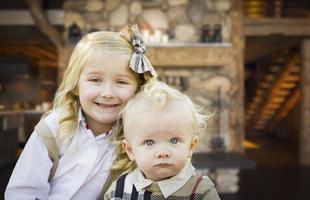 süßer bruder und schwester posieren in einer rustikalen hütte foto