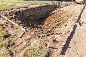 frisch gegrabenes Loch im Hof, das für die Installation des Swimmingpools vorbereitet wird foto