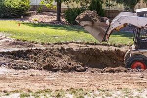 kleiner Bulldozer, der im Hof für die Poolinstallation gräbt foto