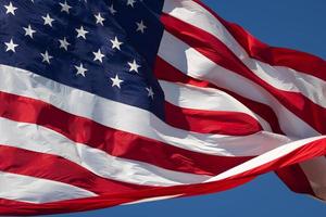 amerikanische Flagge weht im Wind vor einem tiefblauen Himmel foto