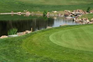 malerisches Golfplatz-Fairway und Grün mit Teich. foto