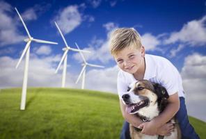 kleiner Junge und Hund im Windkraftanlagenfeld foto