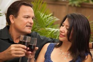 attraktives hispanisches und kaukasisches paar, das wein trinkt foto