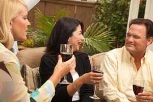 Drei Freunde genießen Wein auf der Terrasse foto