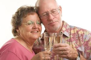 glückliches älteres Paar beim Toasten foto