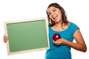 hübsches hispanisches Mädchen, das leere Tafel und Apfel hält foto