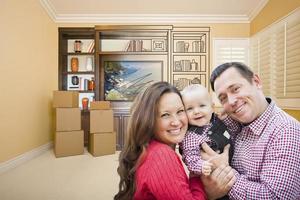 junge familie im zimmer mit zeichnung der unterhaltungseinheit an der wand foto