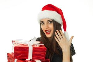 überraschtes Mädchen in Sankt-Hut mit rotem Geschenk foto