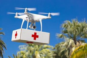 unbemanntes Flugzeugsystem Quadrocopter-Drohne mit Erste-Hilfe-Paket über tropischem Gelände. foto