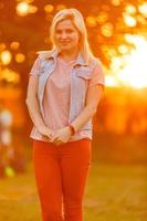 junge Frau, die Natur und Sonnenlicht im Strohfeld genießt foto