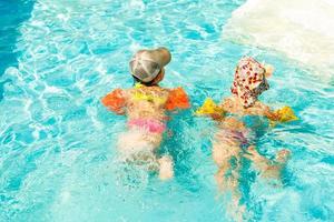 zwei kleine Kinder, die im Swimmingpool spielen foto