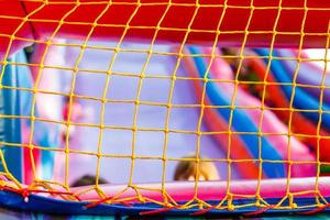 Mesh auf einem aufblasbaren Trampolin. aktive Spiele für Kinder foto