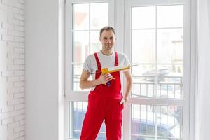 Arbeiter im Overall, der neue Fenster im Büro einrichtet foto