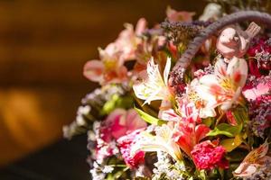 schöner Strauß heller Wildblumen im Korb, isoliert auf weiß foto