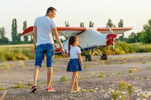 Vater und 7-jähriges Kind spielen Flugzeug foto