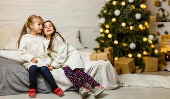 zwei kleine Mädchen im Weihnachtshintergrund foto
