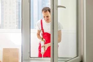 bauarbeiter, der fenster im haus installiert foto