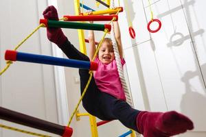 Kleines Kind steigt die Treppe im Fitnessstudio hinauf foto