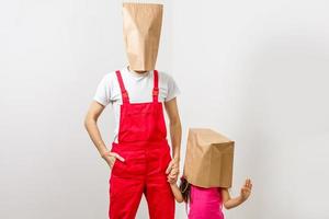 Mann und kleines Mädchen mit Paketen auf dem Kopf foto