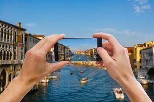 tourist, der ein bild des grand canal und der basilika santa maria della salute in venedig, italien macht foto