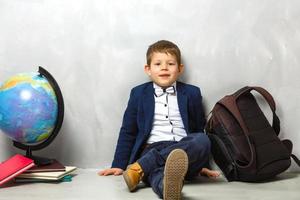 fröhlich lächelnder kleiner Junge mit großem Rucksack. Schulkonzept. zurück zur Schule foto