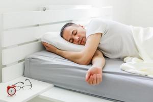 Coronavirus-Quarantäne-Lebensstil. Mann schläft während der Pandemie-Selbstisolation zu Hause im Bett liegend. Panorama foto