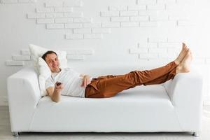 reifer mann auf der couch vor dem fernseher foto