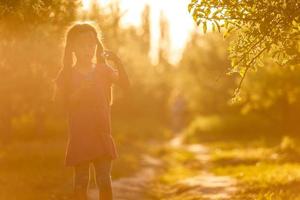 lockiges Mädchen fängt eine Seifenblase. Konzept der glücklichen Kindheit foto