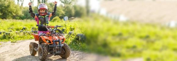 Das kleine Mädchen fährt Quad. Ein Mini-Quad ist ein cooles Mädchen mit Helm und Schutzkleidung. Elektro-Quad-Elektroauto für Kinder macht grüne Technologie populär foto