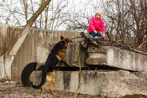 Ein kleines Mädchen versteckt sich vor einem Hund foto