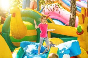 Fröhliches kleines Mädchen, das auf einem Trampolin spielt foto