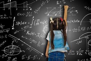 Mädchen gegen große Tafel mit Formeln, Rückansicht foto