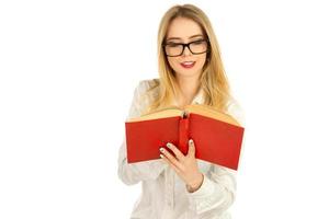 Mädchen mit Brille und weißem Hemd, das ein Buch liest foto