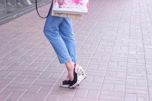 elegante frau auf high heels mit einkaufstüten in den händen foto