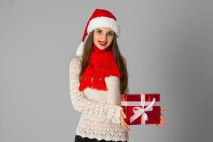 Mädchen in Nikolausmütze mit Geschenk foto