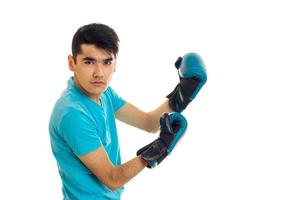 Porträt eines starken Mannes, der Boxen in blauen Handschuhen übt, isoliert auf weißem Hintergrund foto