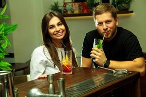 Paar hat Spaß mit Cocktails an der Bar foto
